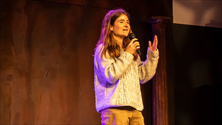 Three Minute Thesis 2022 Eine Teilnehmerin spricht auf der Bühne ins Mikrofon.