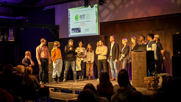 Three Minute Thesis 2022 Alle Teilnehmenden stehen in einer Reihe auf der Bühne.