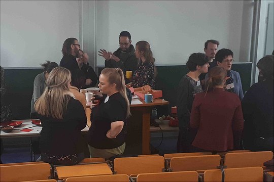 mehrere eifrig diskutierende Teilnehmende zur Kaffepause am Redner-Tisch