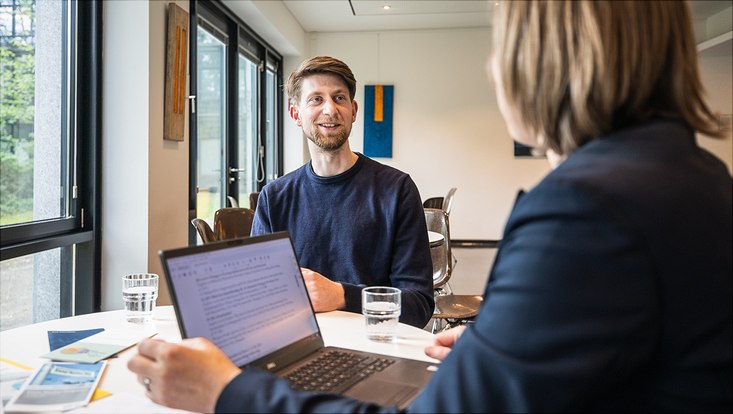 Zwei Menschen unterhalten sich an einem Tisch
