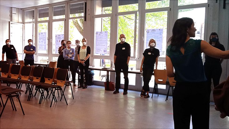 Workshopleiterin erklärt Teilnehmenden nächste Aufgabe