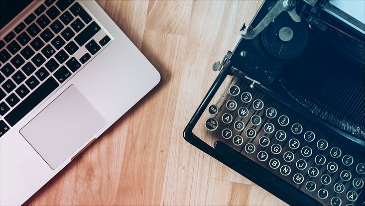MacBook beside typewriter machine