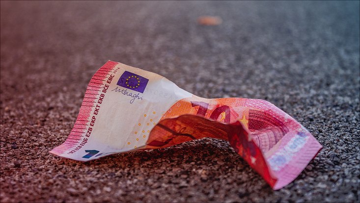 Ein zerknitterter Geldschein auf dem Boden