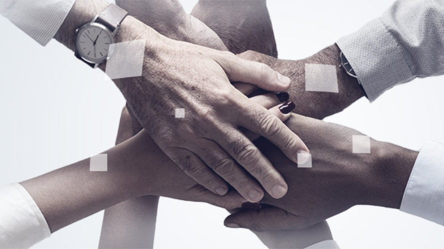 In the centre of the picture are eight hands on a light background, lying on top of each other or inside each other. Above and next to the hands are white, red and blue squares, some of which are tilted in three dimensions.