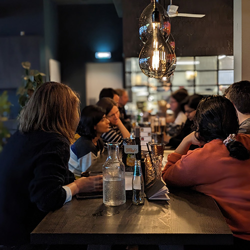 Multiple people sitting aroung a table and chatting