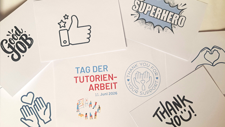 Auf einem Tisch liegen viele Papierkarten zum Tag der Tutorienarbeit 2026 und Glückwünschen