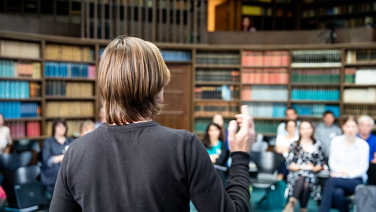 Foto eines Kolloquiums im Warburg-Haus mit einem Sprecher im Vordergrund und in Unschärfe das Publikum im Hintergrund