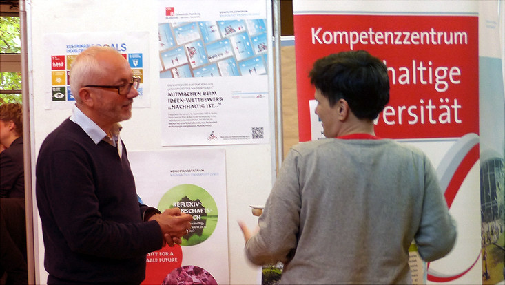Mitarbeiter des KNU in Gespräch vor Informationsstand