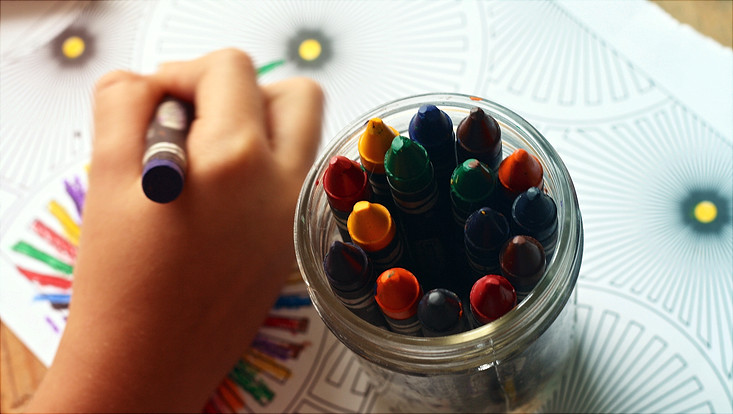 Child painting with wax crayon