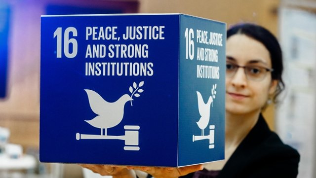 Woman holding cube with SDG 16