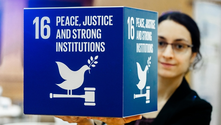 Woman holding cube with SDG 16