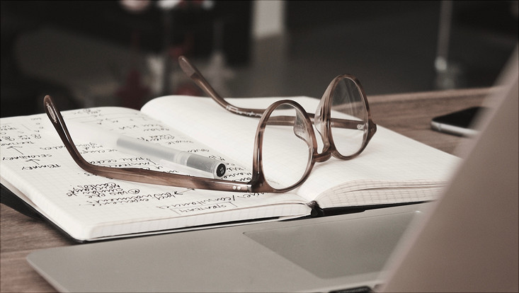 Brille liegt auf Notizbuch
