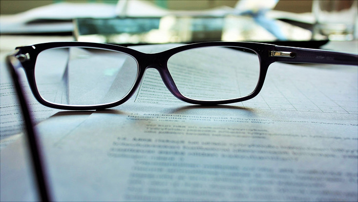 Brille liegt auf beschriftetem Papier