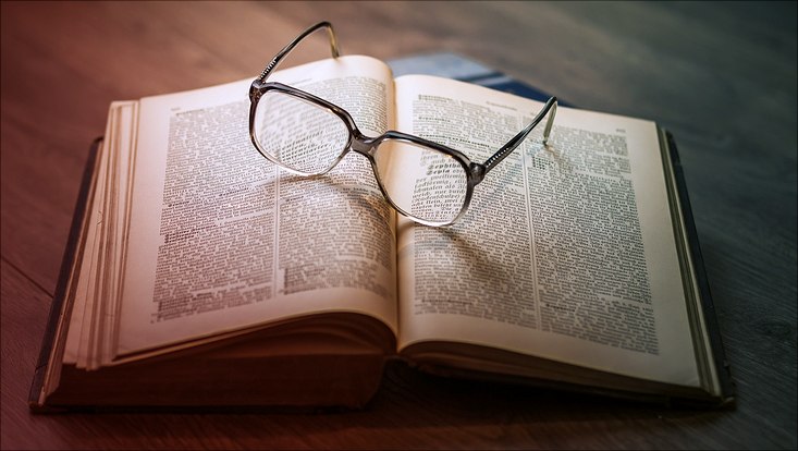 Brille auf aufgeschlagenem Buch