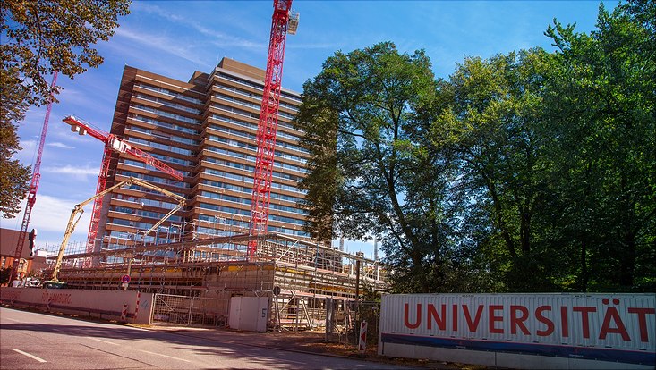 Eine Baustelle vor der ein Banner mit der Aufschrift "Universität" zu sehen ist.