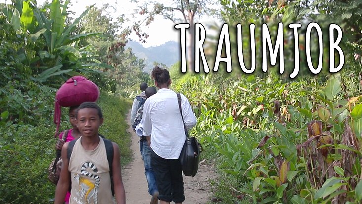 Menschen laufen auf schmalem Pfad durch den Dschungel