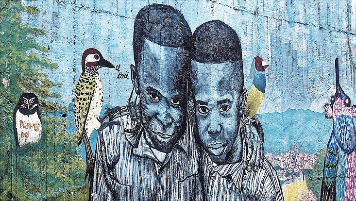 Buntes Wandgraffitti mit zwei Menschen und Papageien