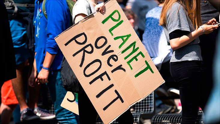 Protest sign saying "Planet over Profit"