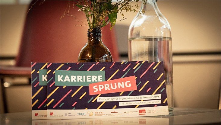 Infokarten des Karrieresprungs 2019 lehnen an einer Vase.