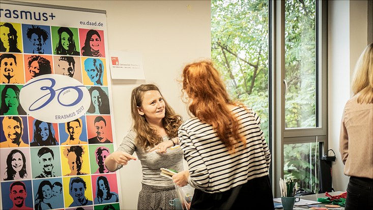 Eine Teilnehmerin steht an einem Infostand von Erasmus+.