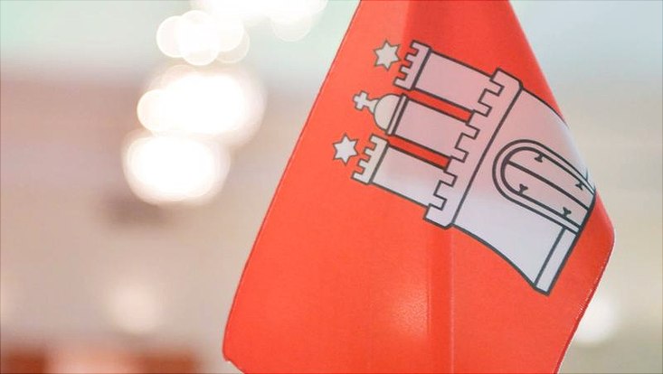 Das Wappen der Stadt Hamburg auf einer Flagge.