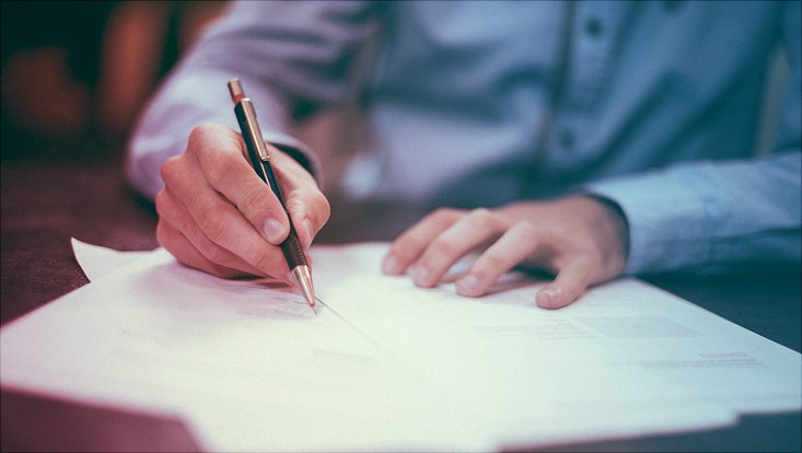 man writing on paper