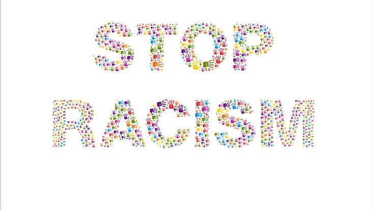 Aus bunten Handabdrücken ist die Aussage "Stop racism" dargestellt