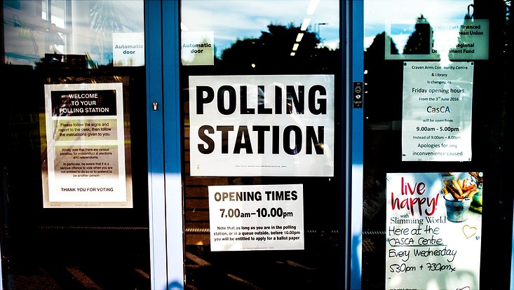 polling station poster on clear glass door