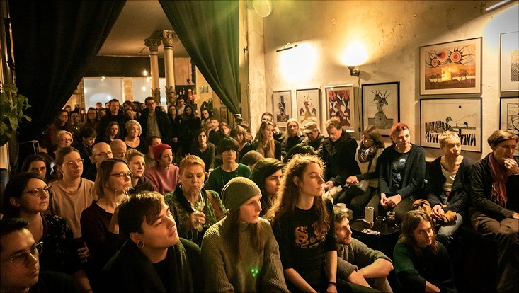 HRA Salon Die Teilnehmenden sitzen dicht nebeneinander und schauen nach vorne.