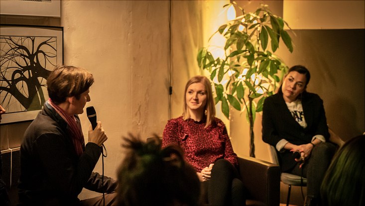 HRA Salon Eine Teilnehmerin stellt über das Mikrofon eine Frage an die Podiumsgäste.