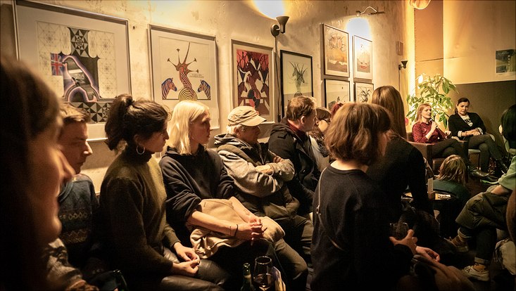 HRA Salon Die Teilnehmenden sitzen dicht gedrängt nebeneinander und hören der Diskussion zu.