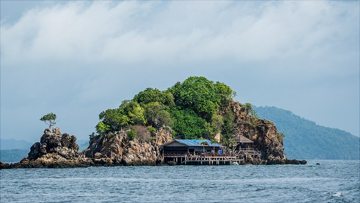 kleine Insel mit Pfahlbau am Wasser